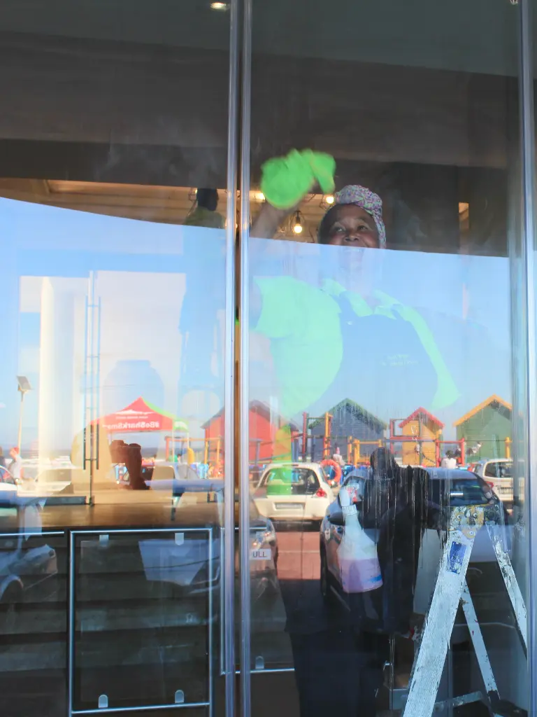 lady cleaning foyer glass doors