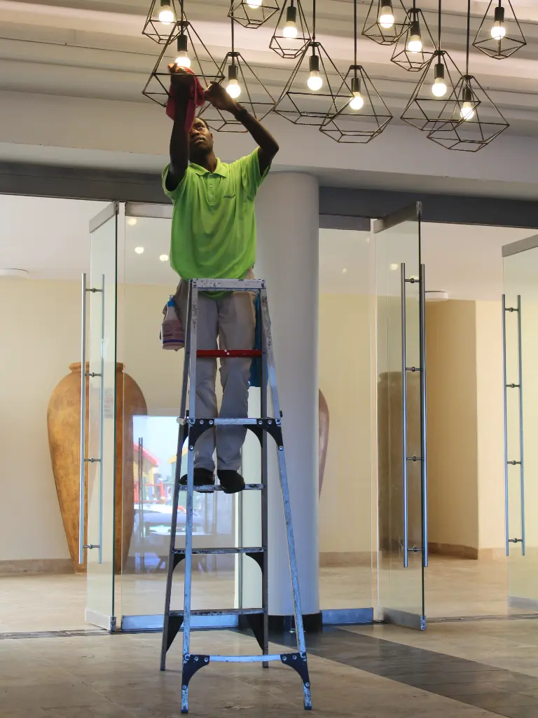 man cleaning and replacing light bulbs